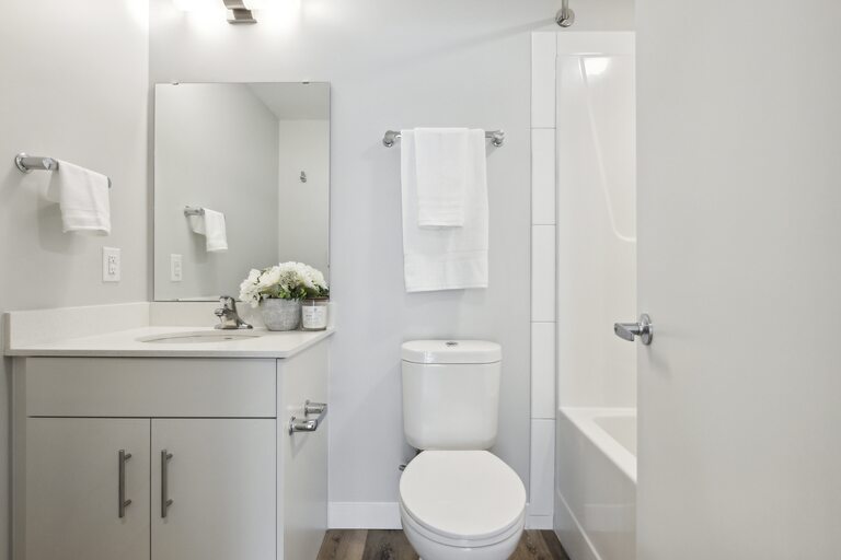 A white bathroom with a toilet, sink, and bathtub.