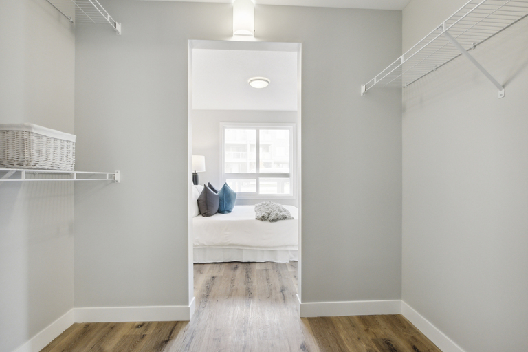 A white bedroom with a bed and a window.