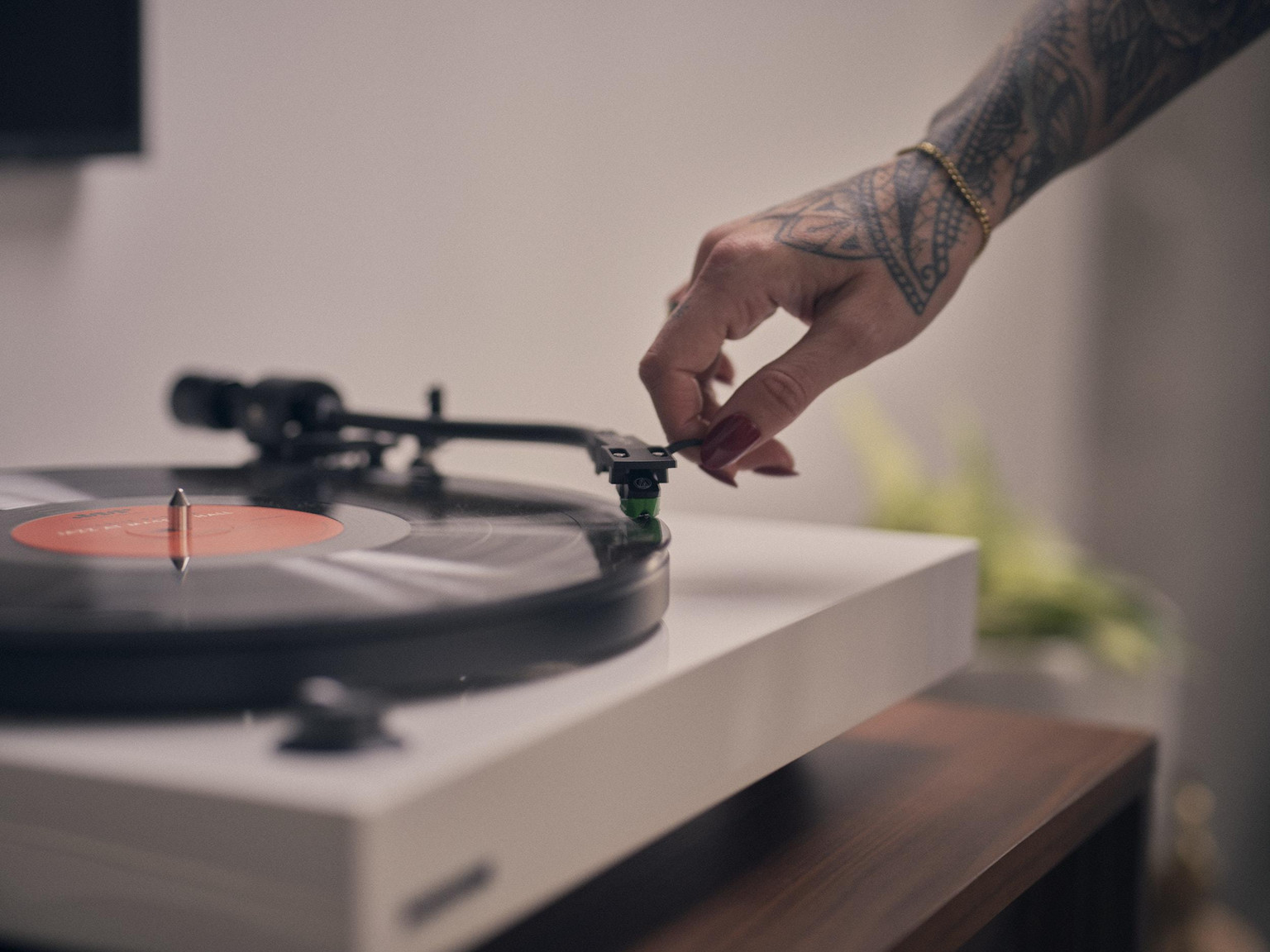 Image - Female hand putting on a vinyl record.