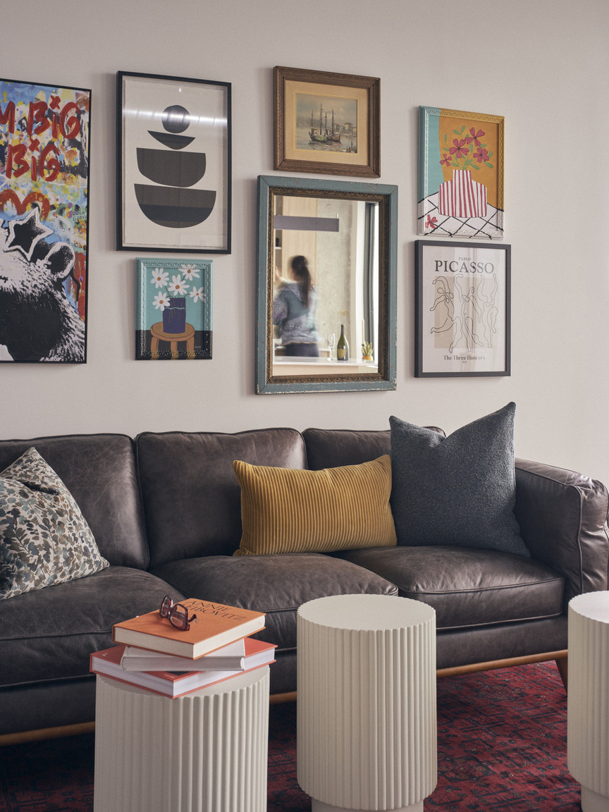 Living room art gallery wall with a reflection of a lady in a mirror