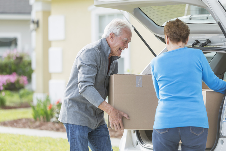 Couple moving boxes into their vehicle