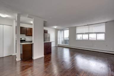 St. Catharines apartment with spacious living area at 137 Church Street featuring hard surface flooring, open kitchen and balcony entrance.