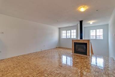 Toronto apartment with spacious living area at 1155-1199 Lansdowne Avenue featuring hard surface flooring, built in fireplace, and vast windows.