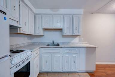 Toronto apartment with sizable kitchen at 38-40 Lambton Avenue featuring a fridge, stove, wide countertops, and an abundance of cabinet space. 