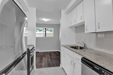 Belleville apartment with sizeable kitchen at 24 Union Street including stainless steel appliances like a fridge, stove, and ample cabinet space.