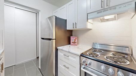 Virtually staged Trenton apartment with spacious kitchen at 405-411 Sidney Street featuring stainless steel appliances and plentiful cabinet space.