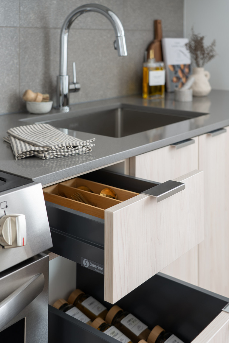Modern kitchen in an Eastward rental home, showcasing gleaming quartz countertops and thoughtfully designed open drawers, highlighting the premium finishes and smart storage solutions in these East Van apartments.