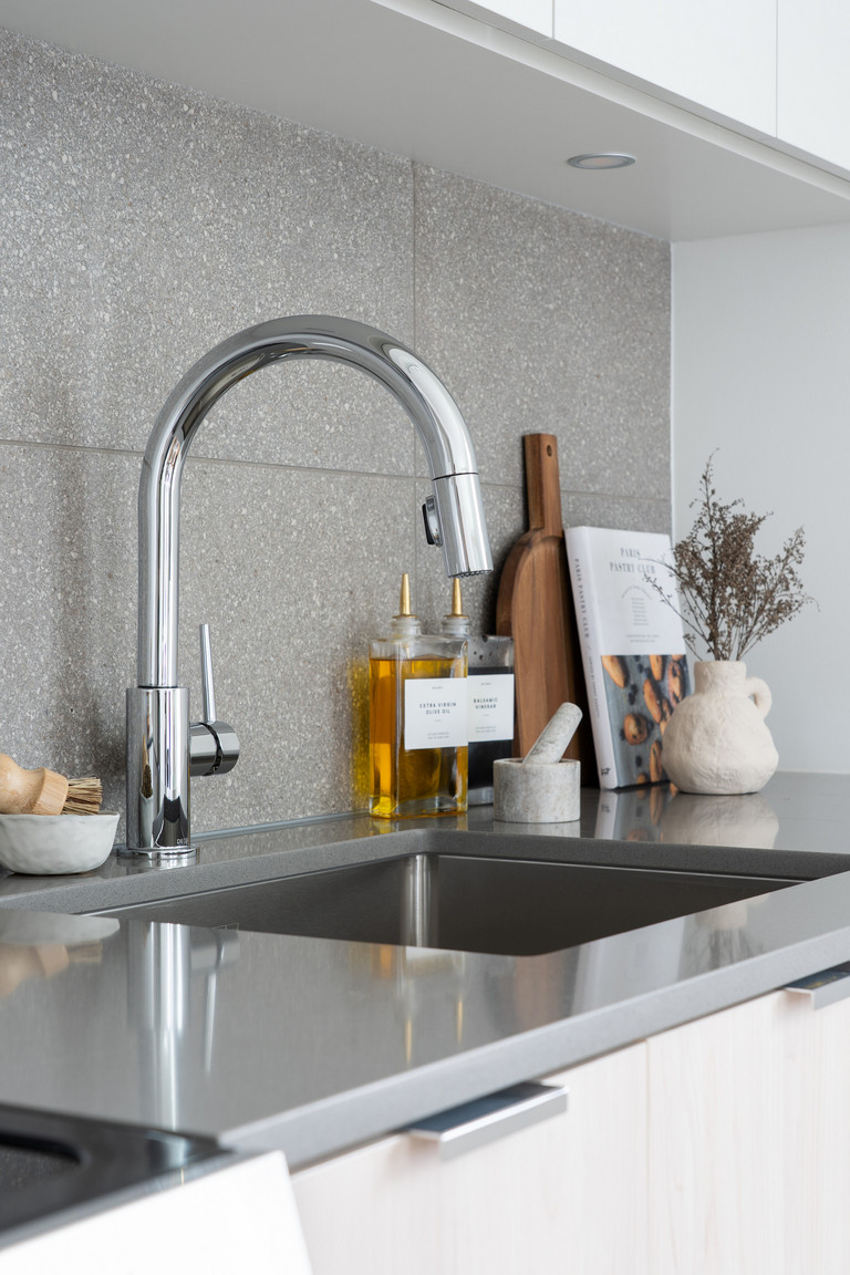 Close-up of a modern kitchen sink and sleek designer faucet in an Eastward rental apartment, highlighting the high-quality fixtures and thoughtful details in these East Van homes.