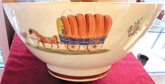 Martyn Edgell Antiques Ltd. from the U.K. offered this large Staffordshire bowl painted with a covered wagon on the exterior and a farm scene on the interior. It sold to a museum.