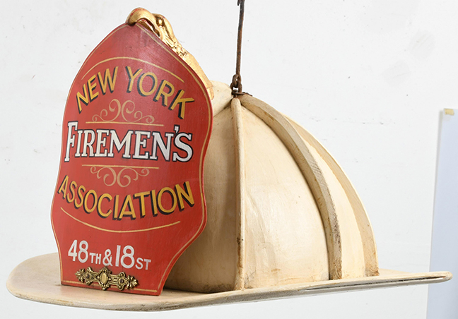 This helmet is made of wood with the New York Firemen’s Association shield and 48th and 18 St. In original condition with iron hangers for hanging. It is from early to mid-20th century and is in original paint, no repairs. The rear hanger could be an old replacement? It measures 32 inches x 20 inches x 17 inches. These fire signs are very unusual. A similar example was sold at Julia Auction, August 18, 2017. Item # 3186. Julia’s example doesn’t have the eagle finial.