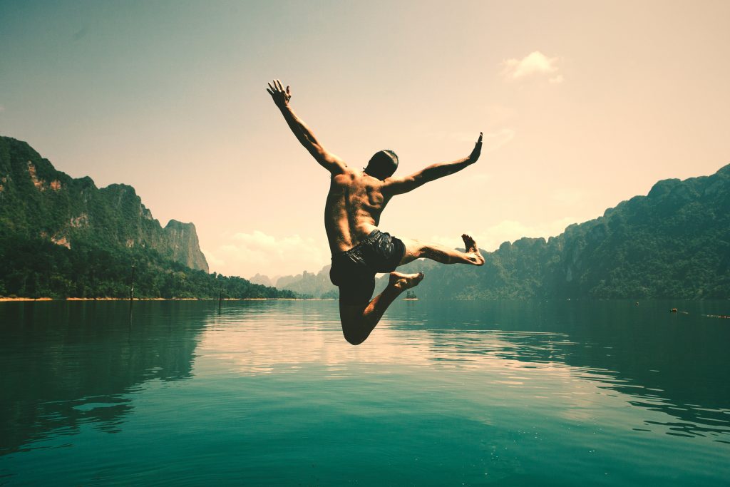 Image of a man doing a happy dance by a lake. Rex Hillier talks about health and happiness in this blog. Photo by Rawpixel.com from Shutterstock