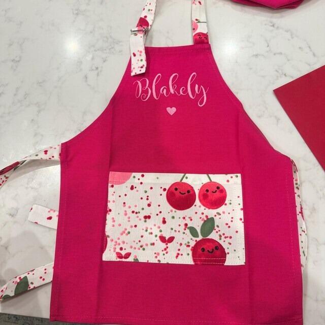Child wearing personalized embroidered apron — customer photo