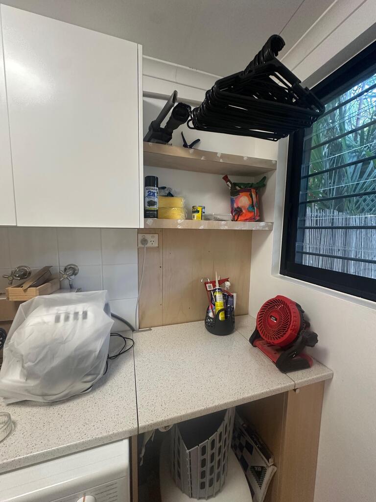 Before: laundry splashback with chipped and cracked tiles