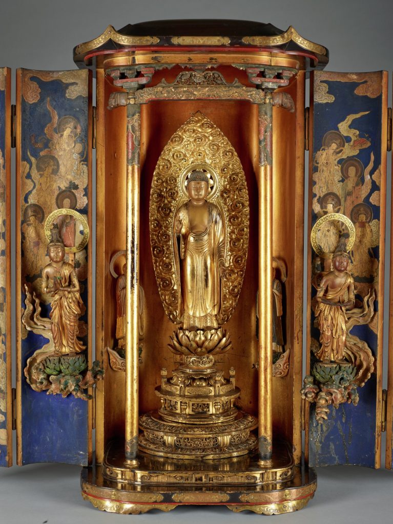 Photograph showing a large sculpture depicting a golden shrine-like structure with five statues and ornate details.