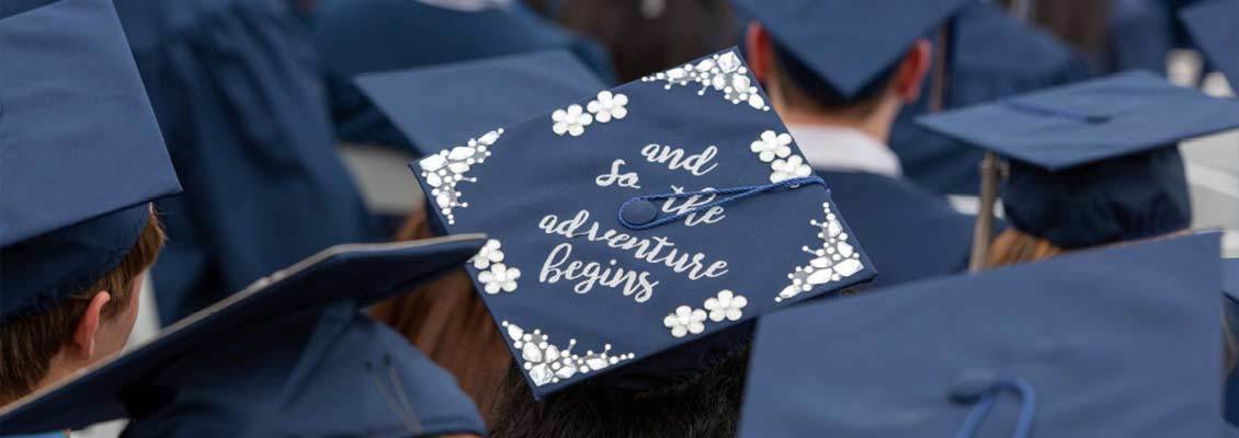 Graduation cap that reads: And so the adventure begins...