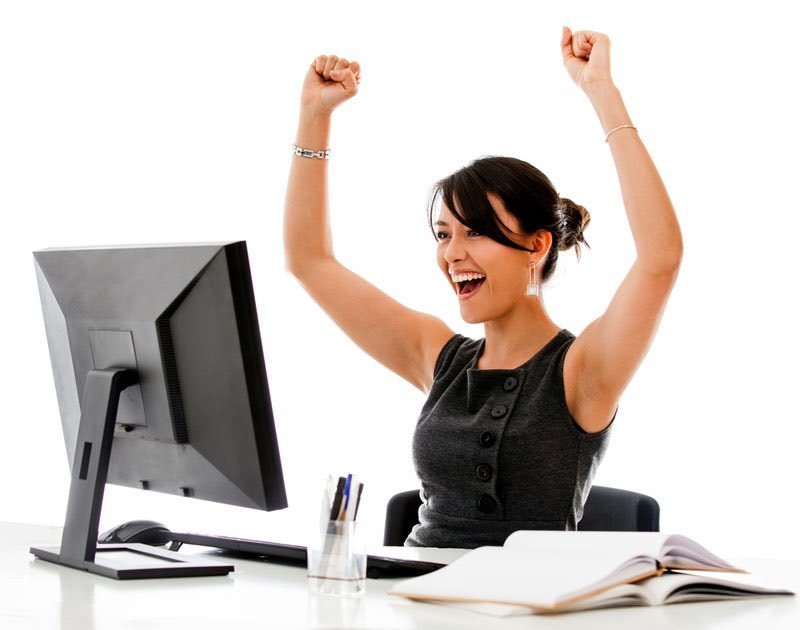 Woman raising her hands in success in front of computer