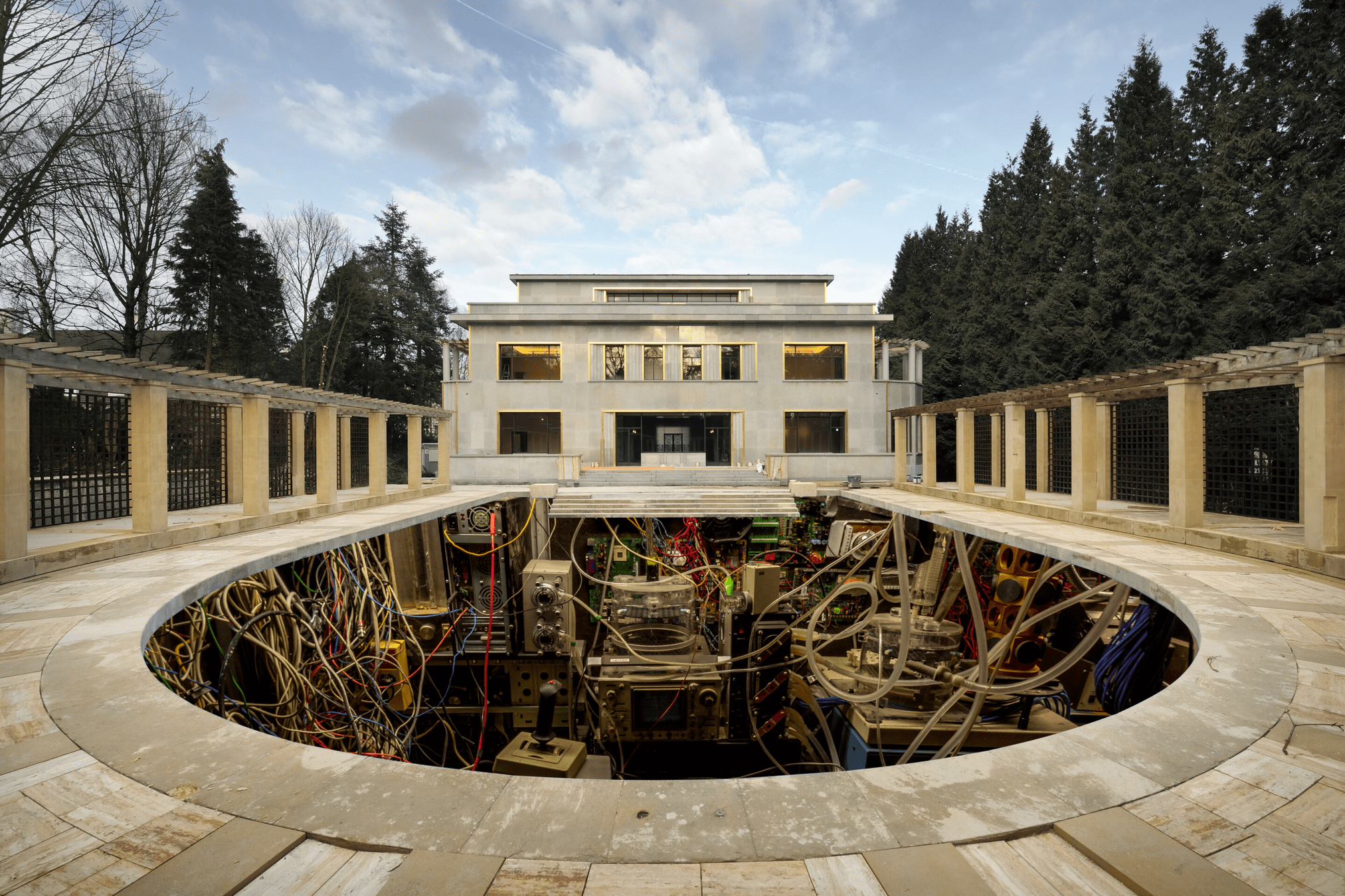 Paper collage. The Art Deco swimming pool of the Villa Empain in Brussels, its elegant facade visible in the background, with the water replaced by rows of computer servers.