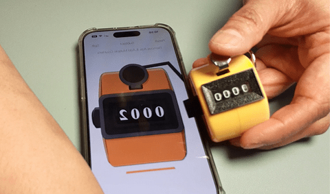 A digital clicker counter app on a phone and a handheld clicker counter