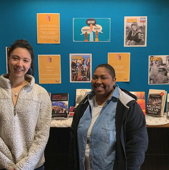 photo of a student and a librarian standing in front of a pop-up exhibit