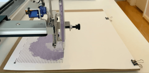 A pen plotter plotting Animonica is sparkly purple ink