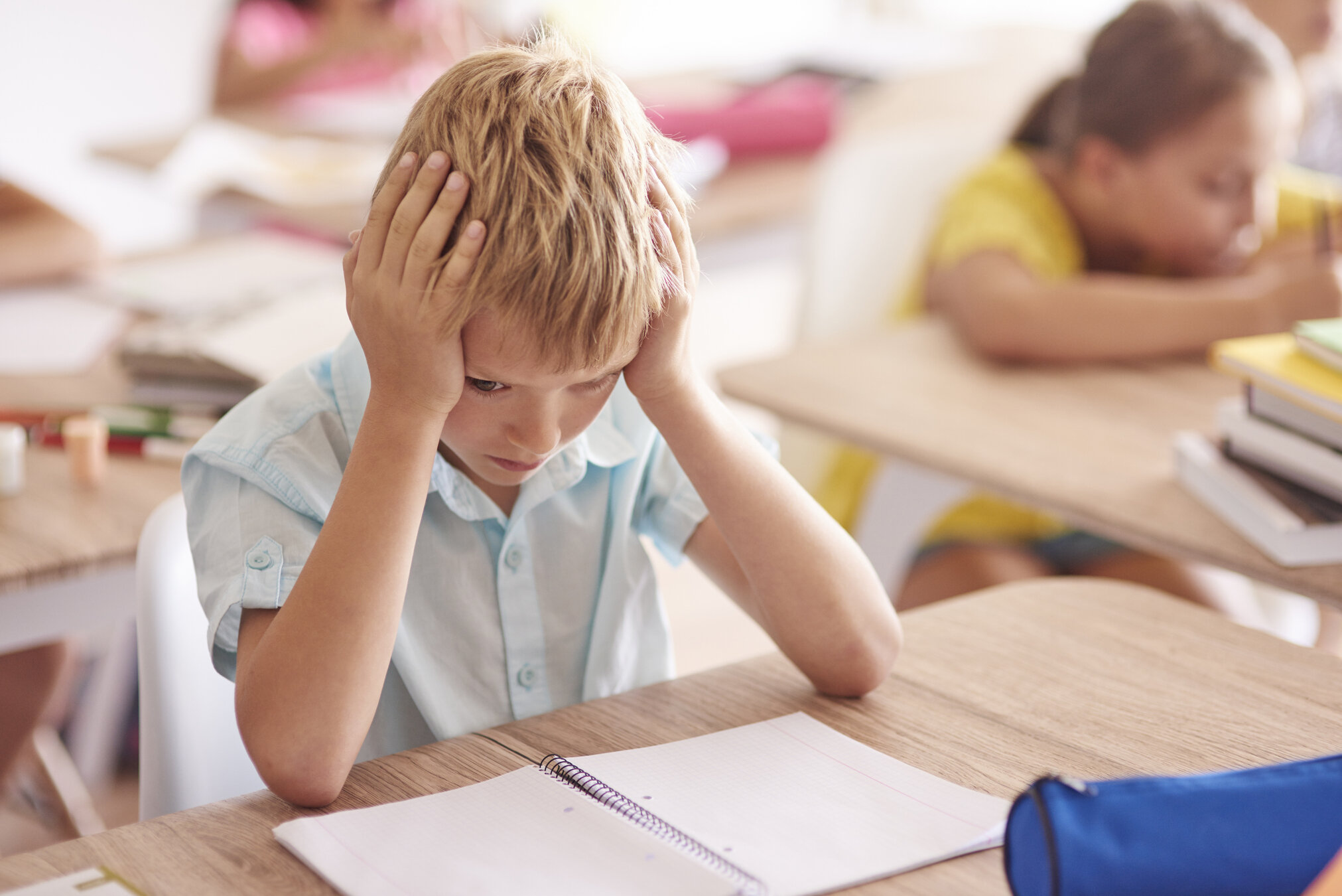 Student with hands on head at desk