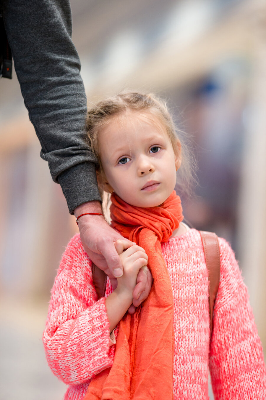 Girl holding adult's hand