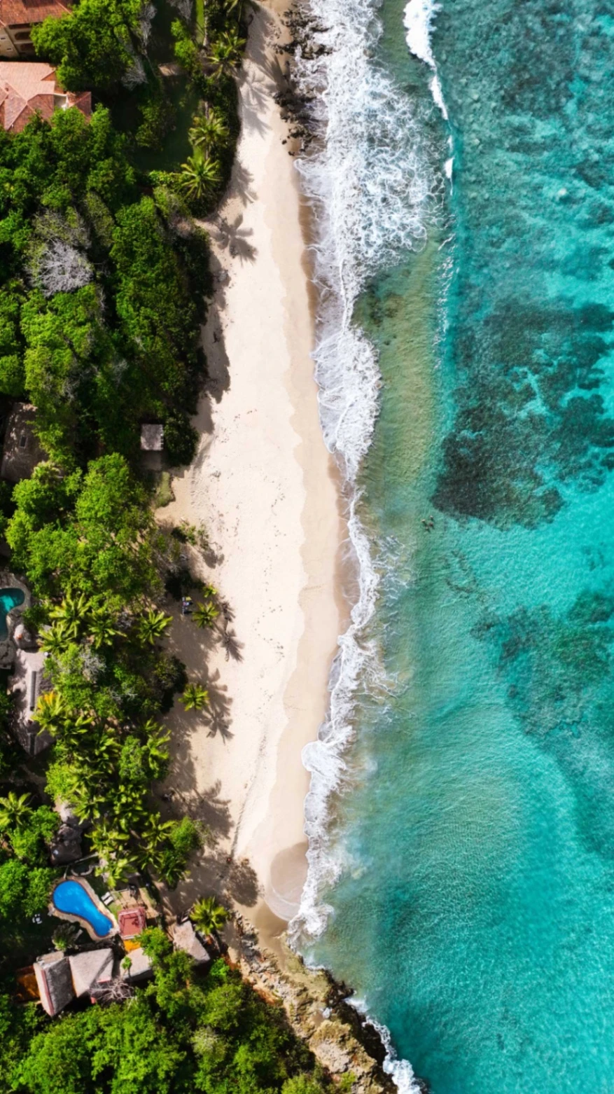 Surfer walking towards the ocean at Encuentro Beach during golden hour