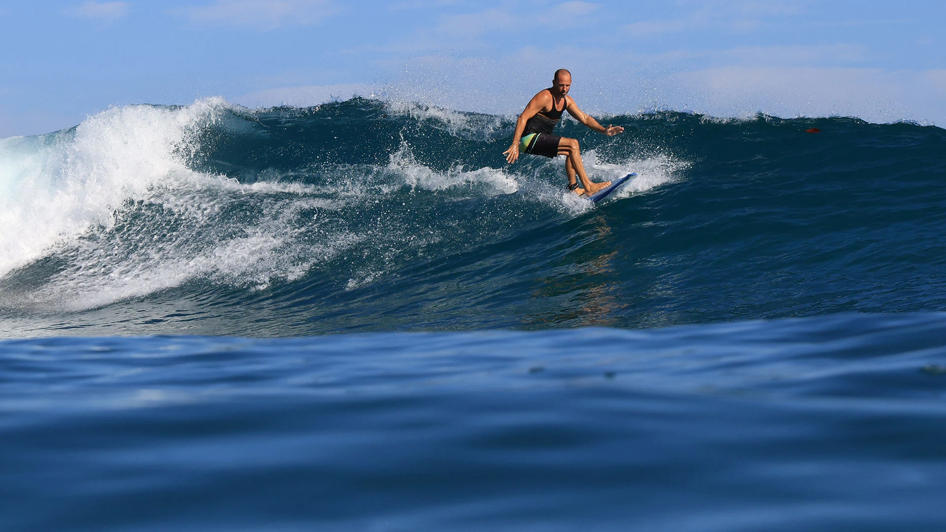 Surfer walking towards the ocean at sunset