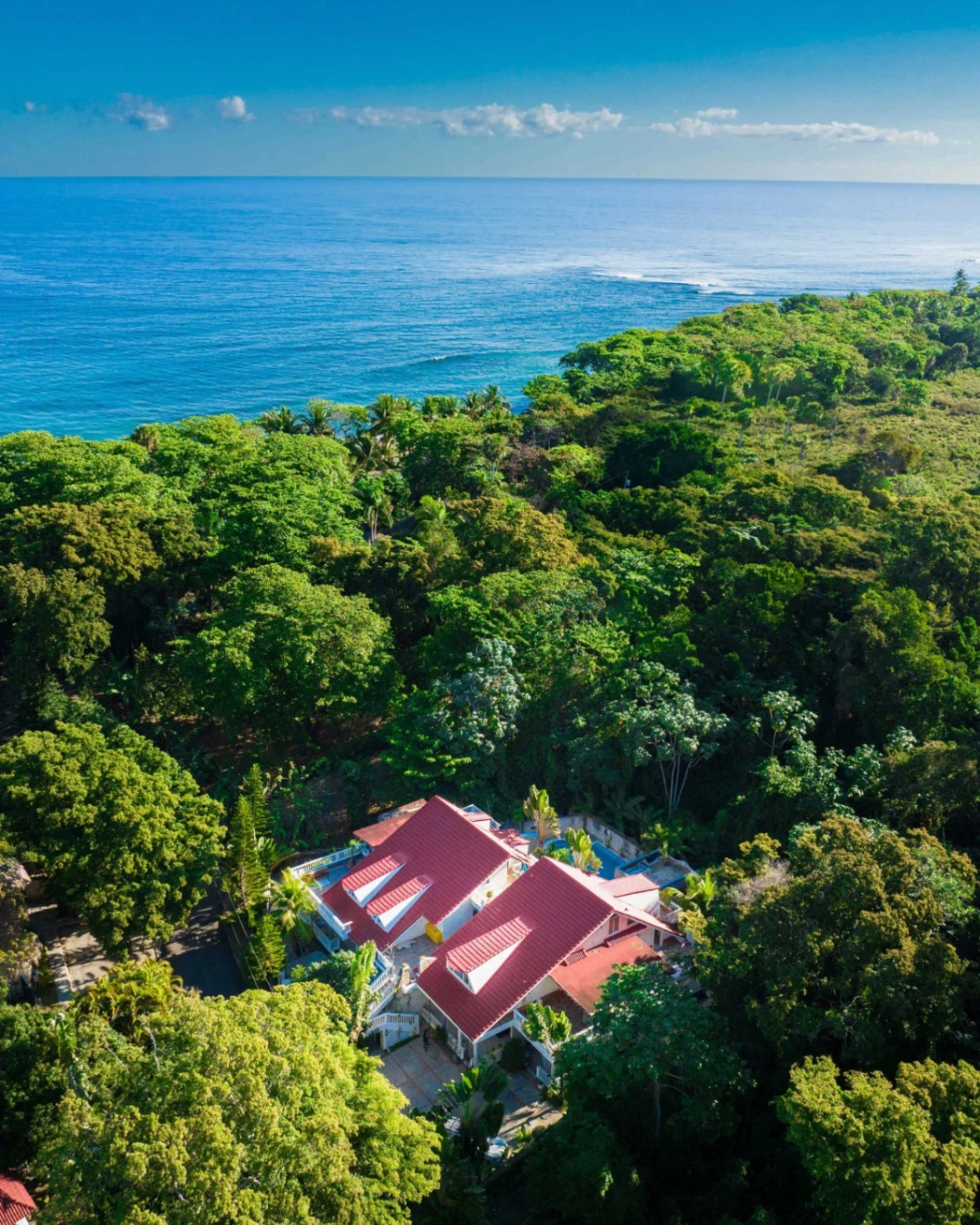 Surfer walking towards the ocean at sunset with a surfboard