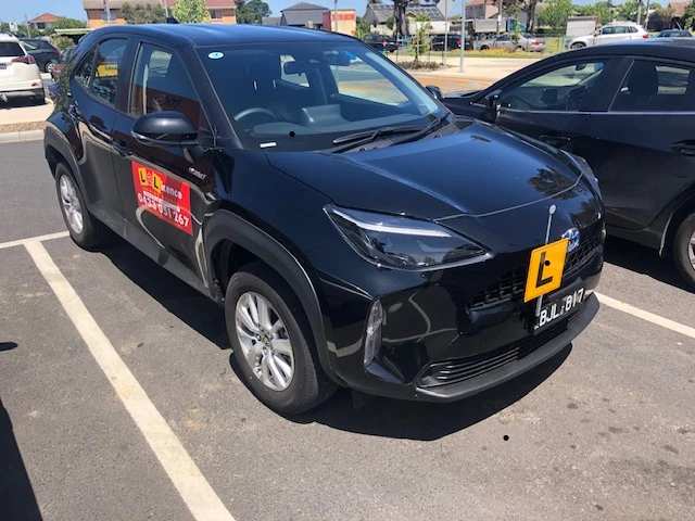 Professional driving instructor teaching a student in a modern vehicle