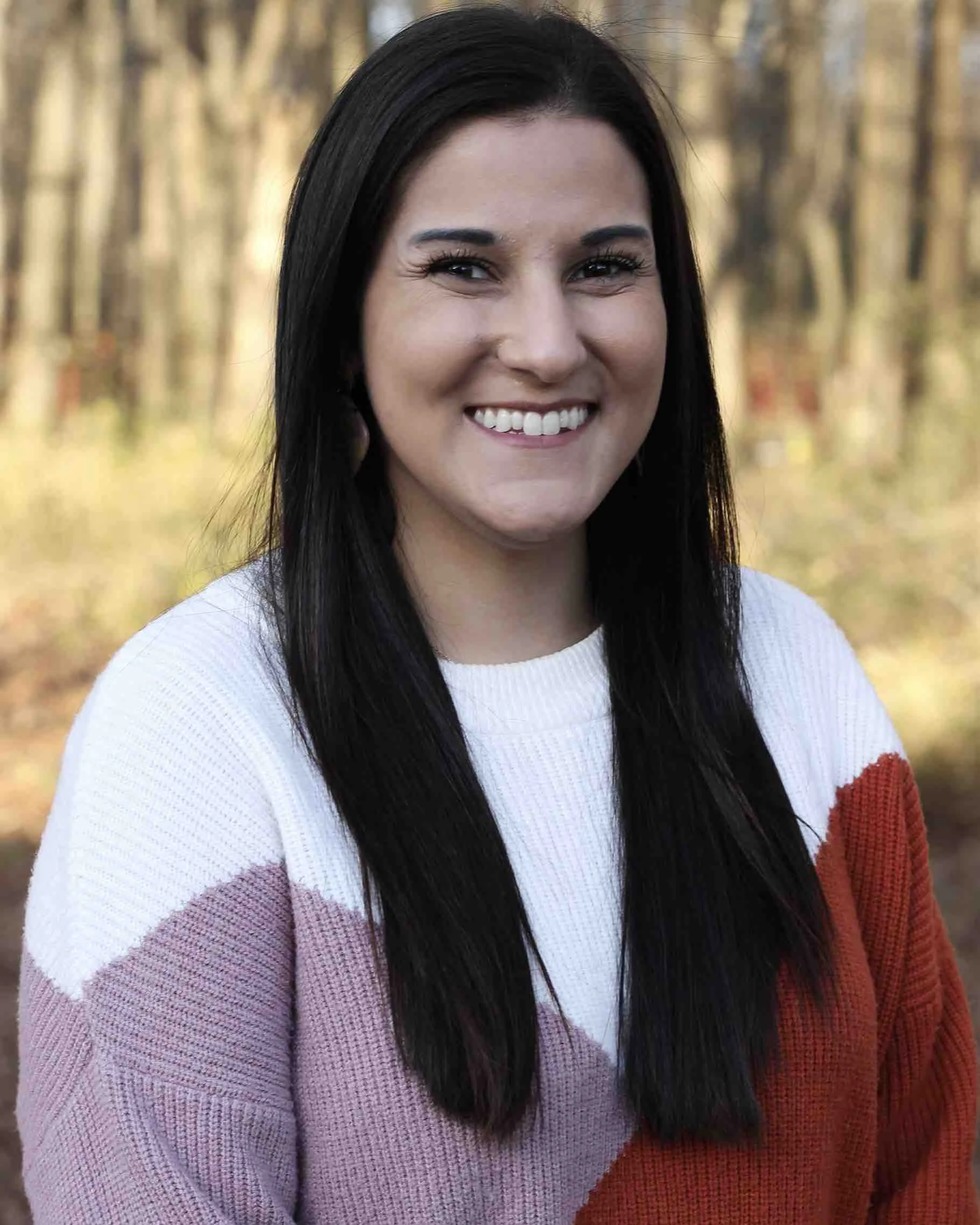 Portrait of Elena Vance smiling warmly in a natural, sunlit setting