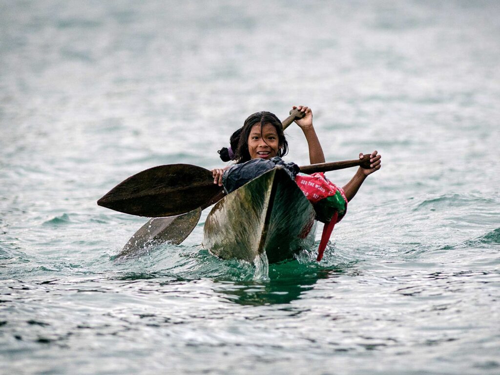 Indigenous people paddling a canoe