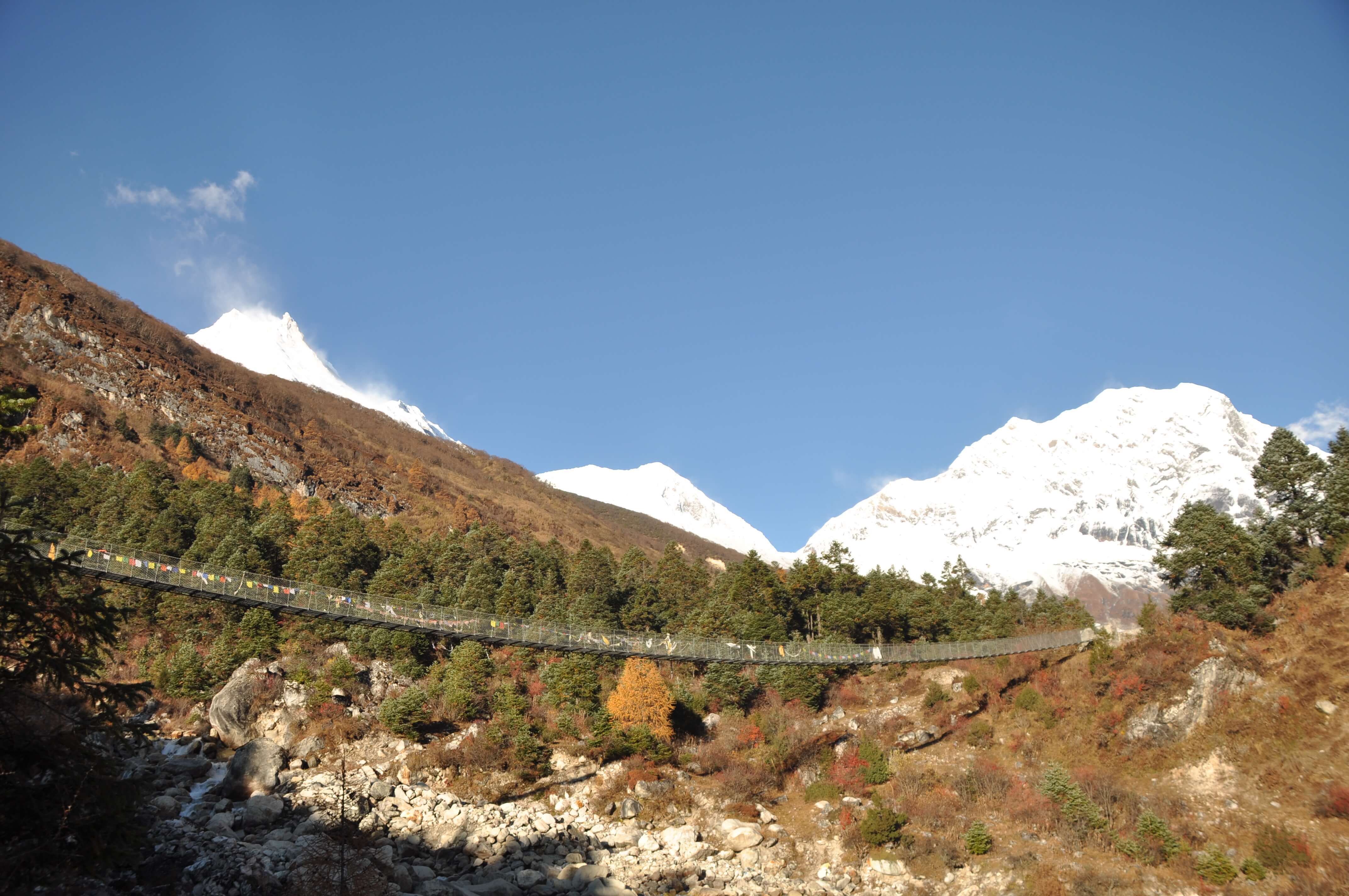 Crossing a suspension bridge on the Manaslu Circuit Trek.