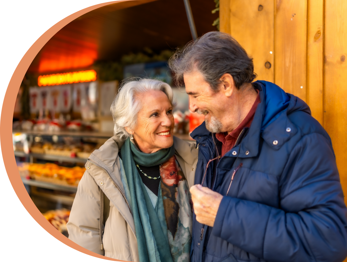hero senior couple laughing outside bakery on a winter day