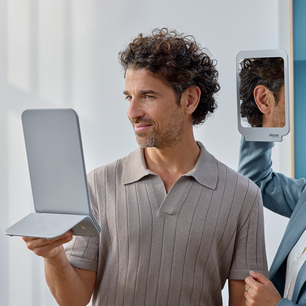 oticon zeal lifestyle man trying hearing aid with professional
