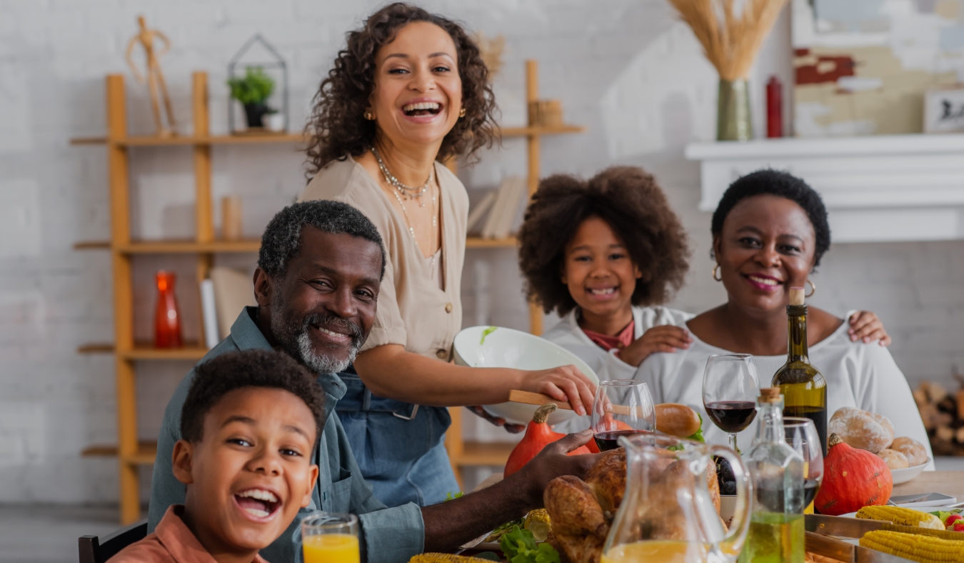 black family smiling towards camera during autumn dinner