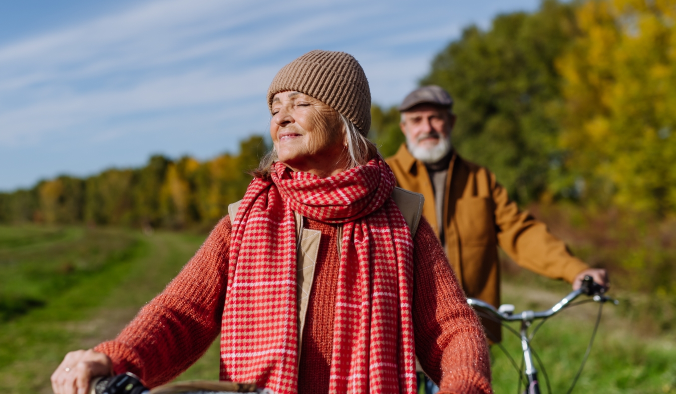 elderly couple on a walk in the forest with bikes