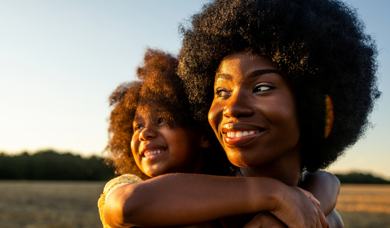 mother daughter smiling in sunflower field