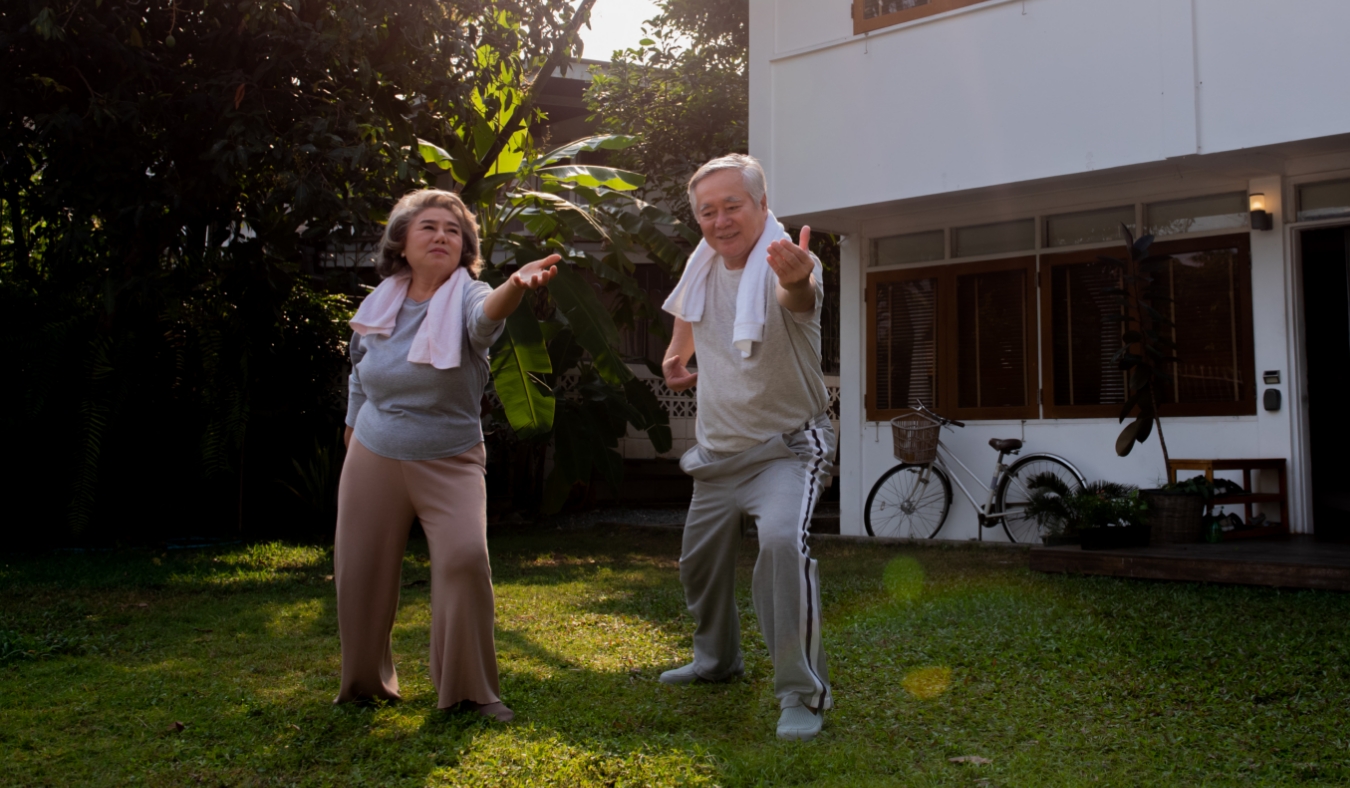 senior asian couple enjoying morning yoga outside