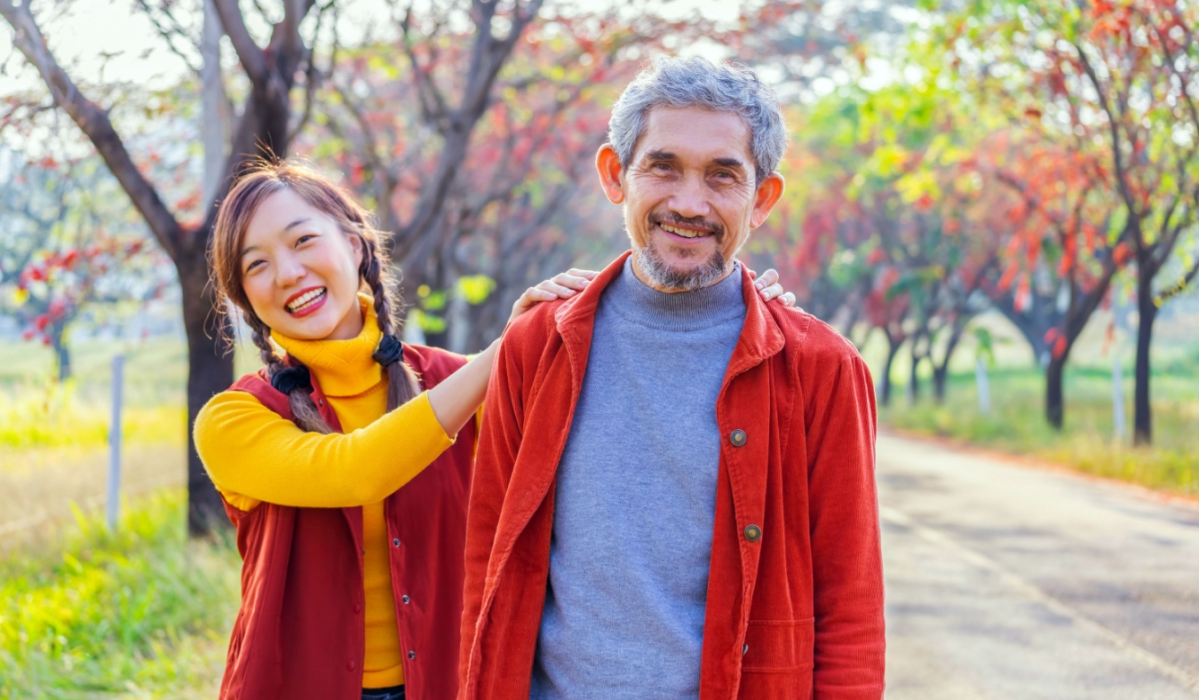 senior father and adult daughter outside during leaves color changing