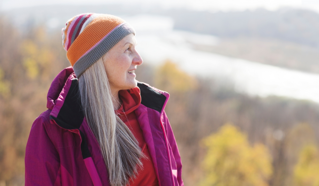 senior woman admiring autumn view mountain range