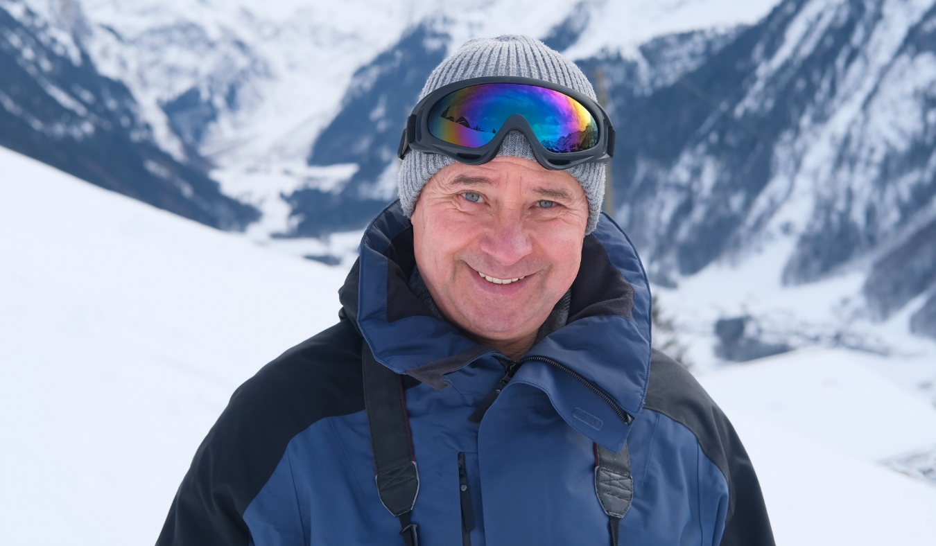 elderly man admiring mountain winter landscape