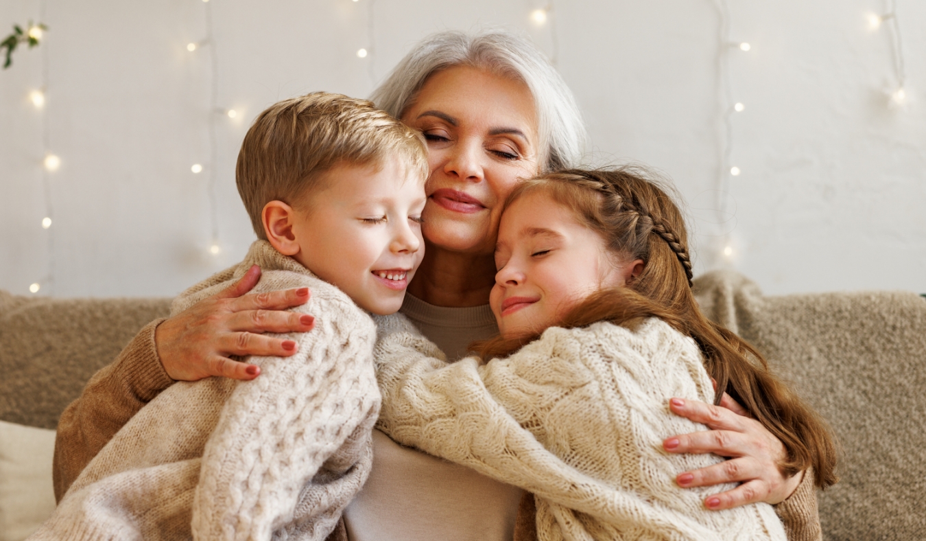 grandkids embracing grandmother on couch