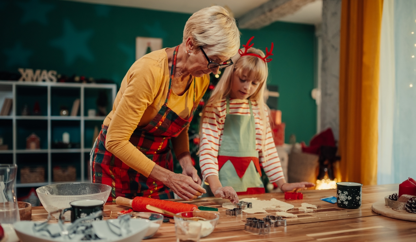 grandmother and granddaughter making holiday cookies