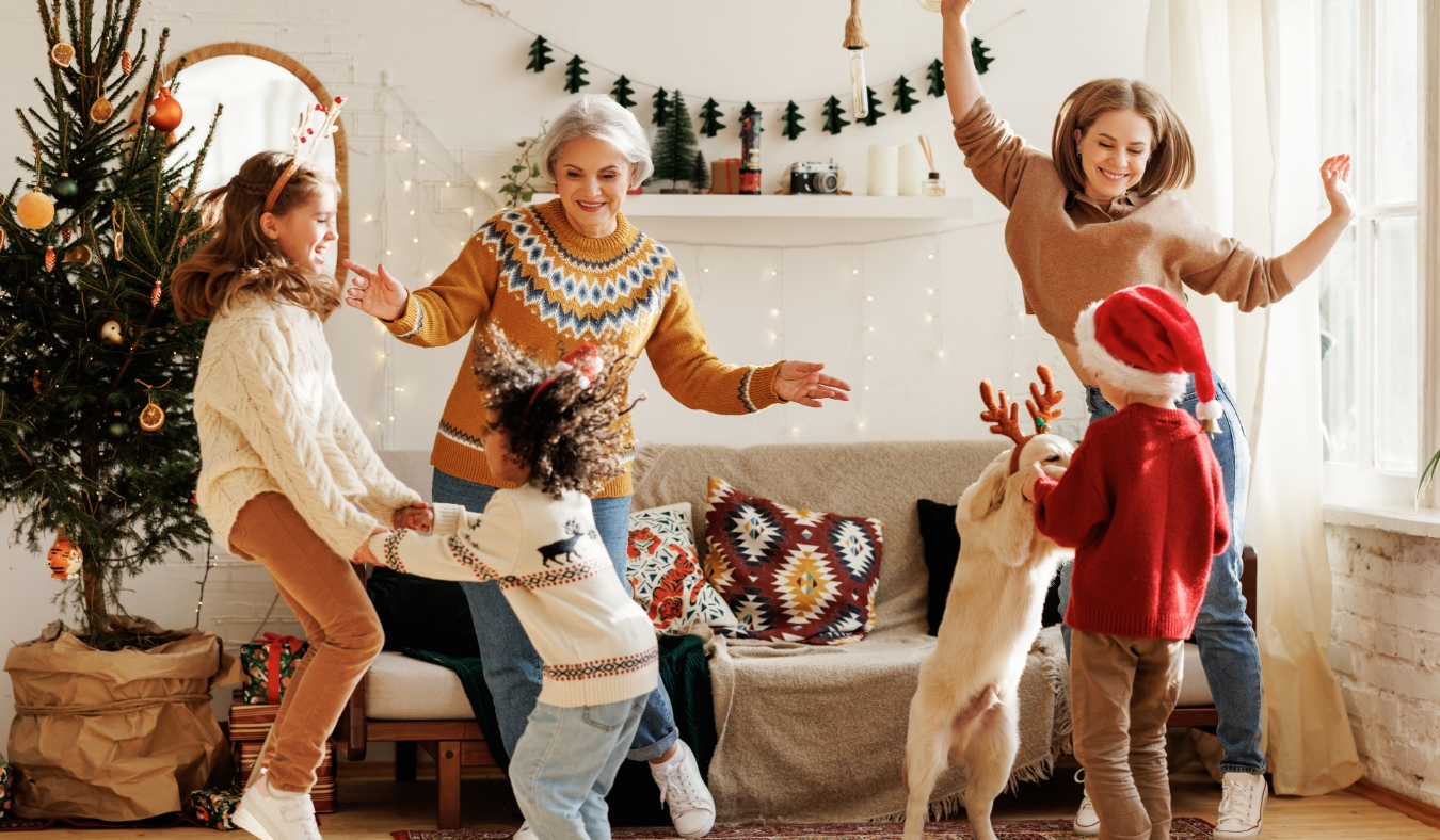grandmother daughter grandkids dancing to christmas music in living room