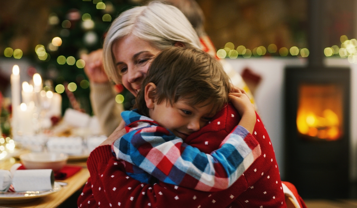 grandmother embracing grandson during christmas celebrations