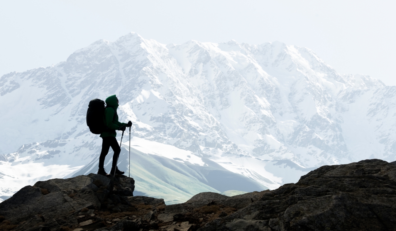 hiker silhouette against snowy mountains