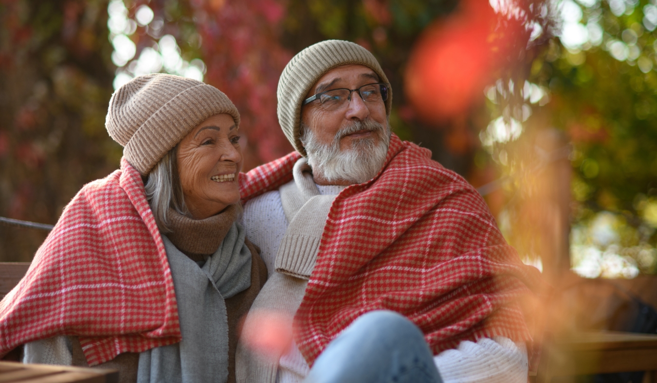 married couple sitting on a coffee shop terrace on beautiful autumn day