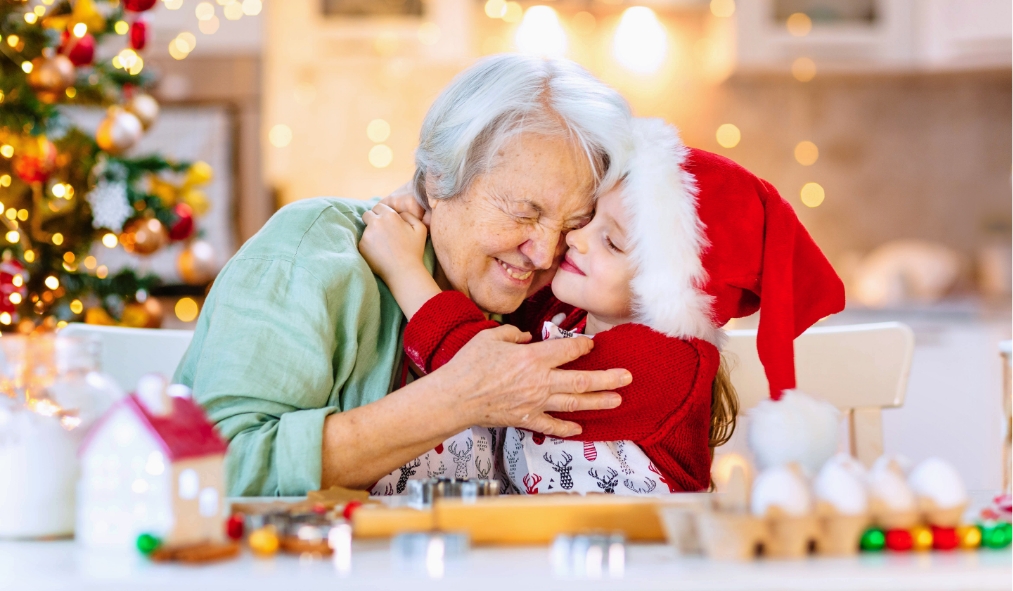 events baking granddaughter hugging grandmother decorating christmas cookies