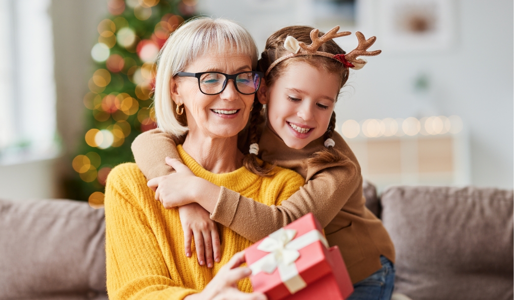events christmas granddaughter hugging grandmother after giving present